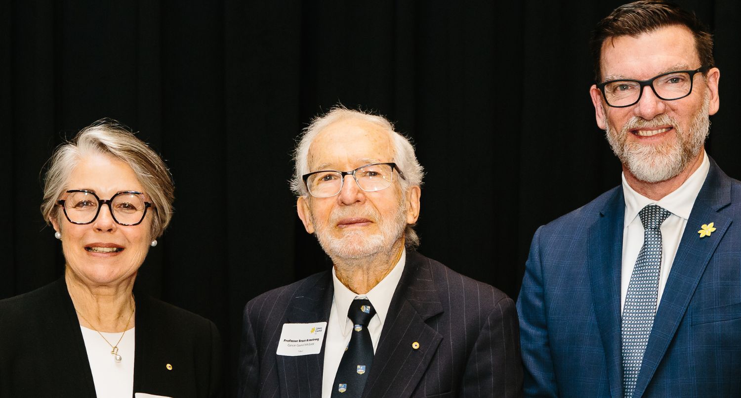 A woman and two men in suits standing together.