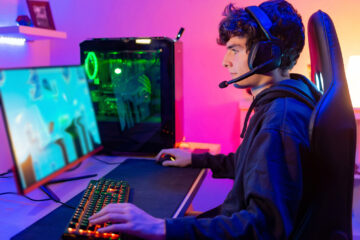 Young person with headset looking at computer screen.
