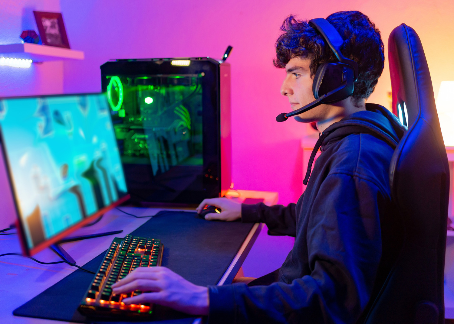 Young person with headset looking at computer screen.
