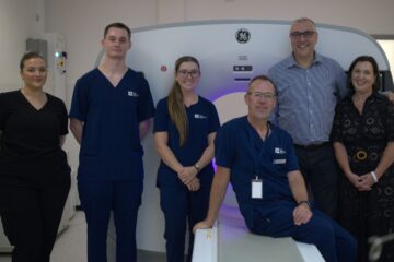 A group of medical professional in front of an MRI machine.