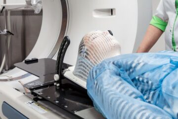 A patient wearing a gown about to have radiation therapy.