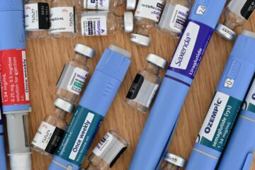 A variety of GLP-1 medications laid out on a surface.