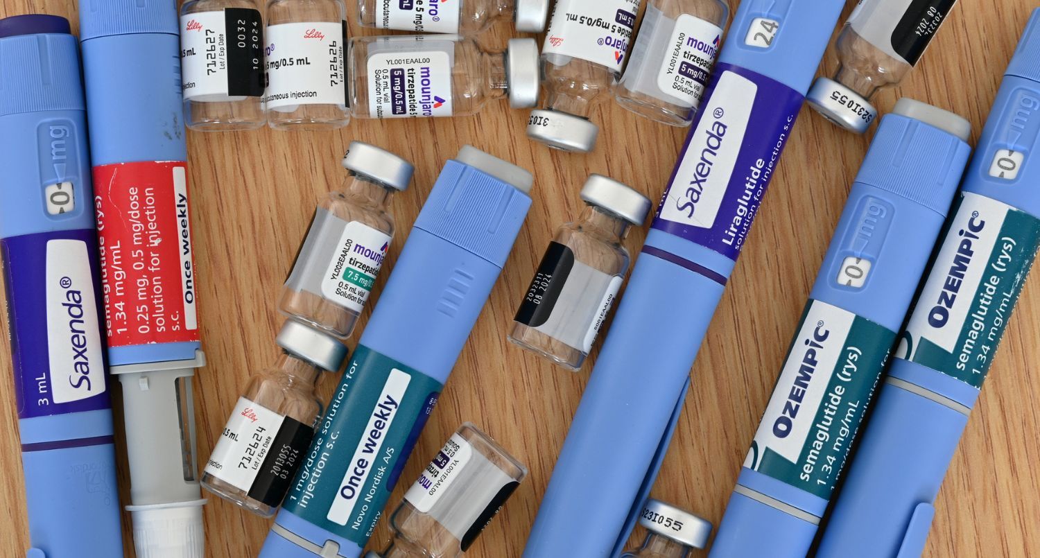 A variety of GLP-1 medications laid out on a surface.