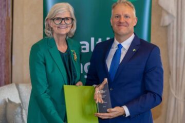 A woman presenting an award to a man.