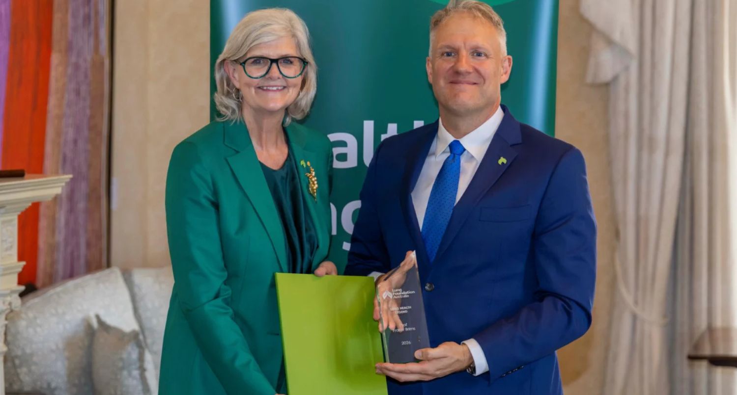 A woman presenting an award to a man.