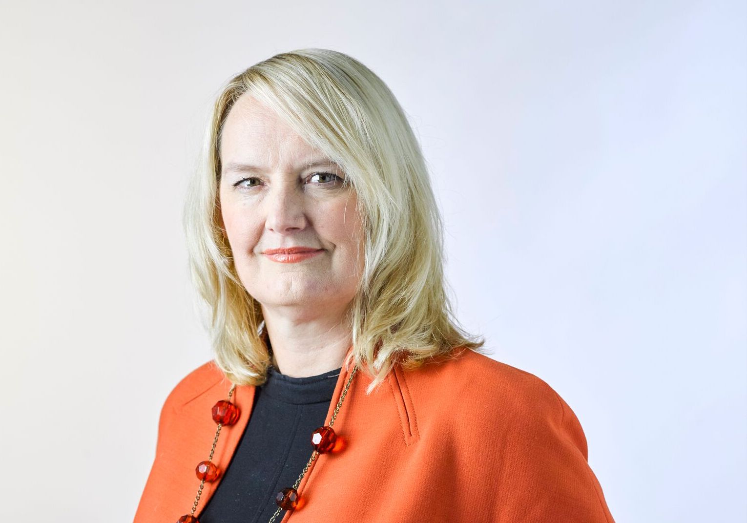 A woman wearing an orange jacket.